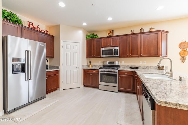 kitchen featuring light stone counters, sink, and appliances with stainless steel finishes