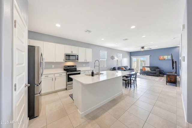 kitchen featuring a sink, light countertops, stainless steel appliances, open floor plan, and visible vents