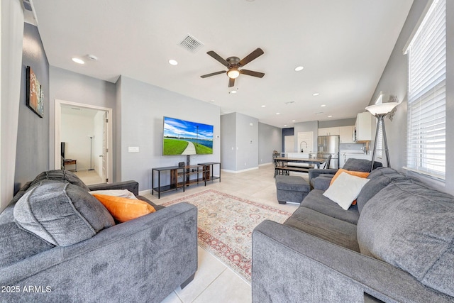 living area featuring visible vents, baseboards, ceiling fan, and light tile patterned flooring