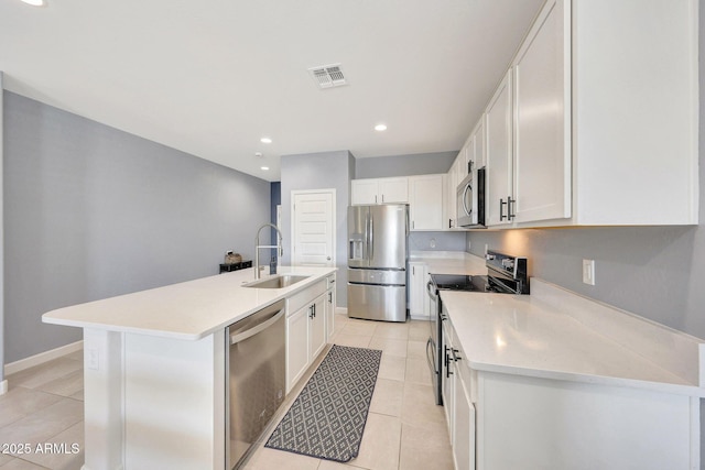kitchen with visible vents, a center island with sink, a sink, light tile patterned floors, and stainless steel appliances
