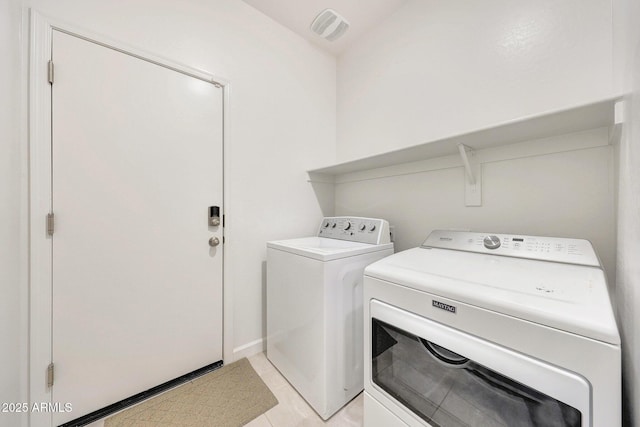 clothes washing area with laundry area, visible vents, and washing machine and dryer