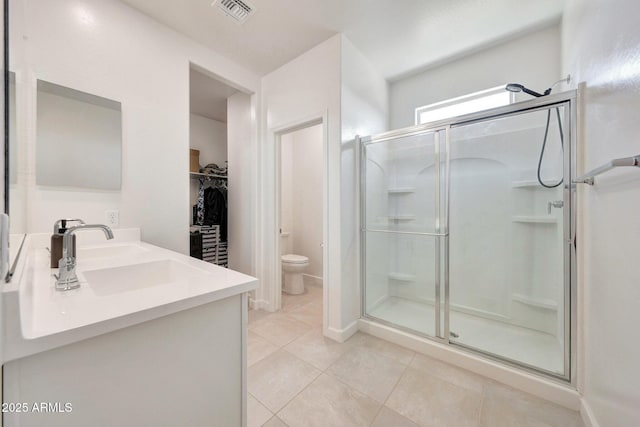 bathroom featuring visible vents, a sink, tile patterned floors, and a shower stall