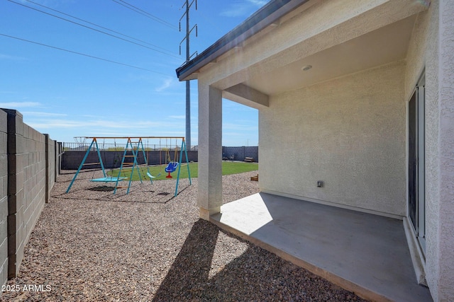 view of patio featuring a fenced backyard and a playground