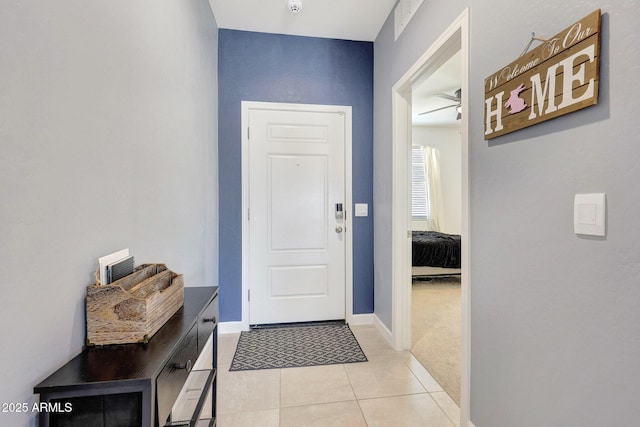 doorway with baseboards and light tile patterned flooring