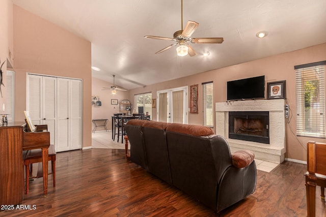 1382 N Tamarisk Dr, Chandler, AZ 85224 - living area featuring a ceiling fan, lofted ceiling, a fireplace, dark wood-style flooring, and healthy amount of natural light