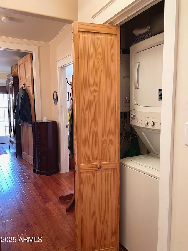 washroom with dark hardwood / wood-style floors and stacked washer and clothes dryer