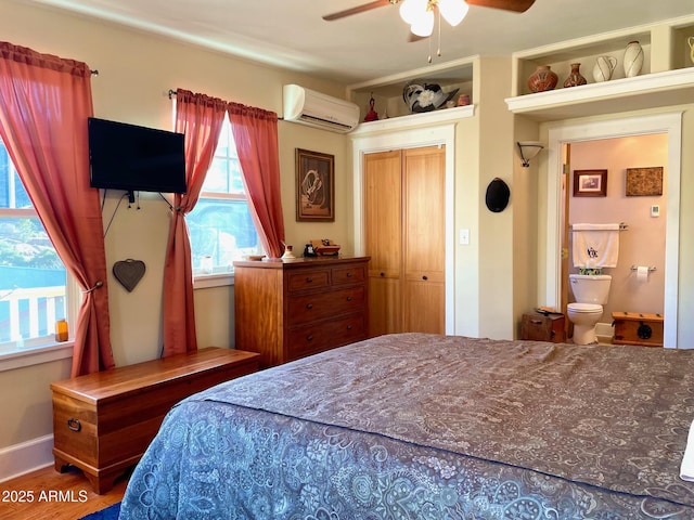 bedroom with a wall mounted AC, hardwood / wood-style floors, and ceiling fan