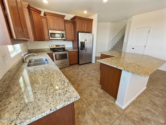 kitchen with light stone counters, appliances with stainless steel finishes, sink, and light tile patterned floors