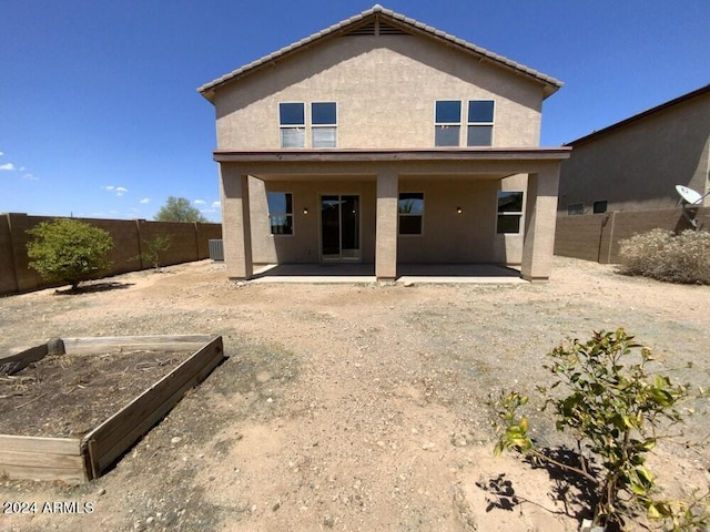 back of property with central AC unit and a patio area