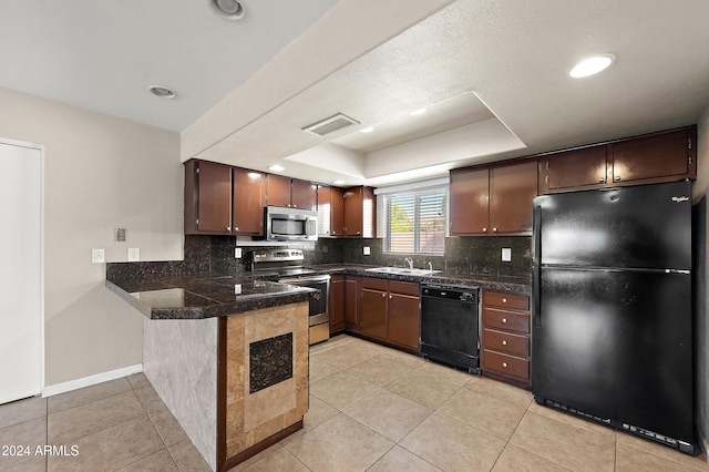 kitchen with kitchen peninsula, sink, black appliances, light tile patterned flooring, and a raised ceiling