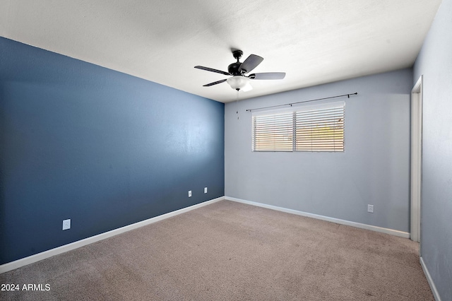 carpeted spare room with ceiling fan