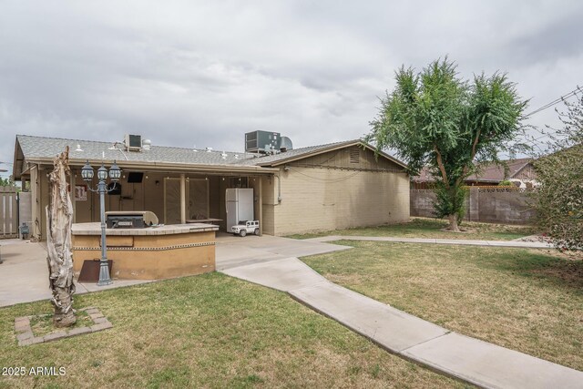5813 N 39th Ave, Phoenix, AZ 85019 - back of property featuring central air condition unit, brick siding, and a patio