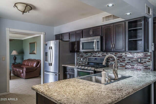 5813 N 39th Ave, Phoenix, AZ 85019 - kitchen featuring stainless steel appliances, a sink, backsplash, a peninsula, and light tile patterned floors