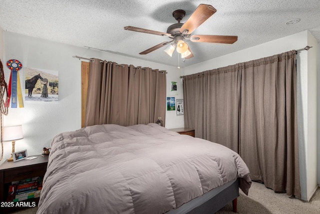 bedroom featuring ceiling fan, light colored carpet, and a textured ceiling