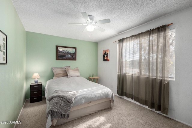 bedroom with a textured ceiling, ceiling fan, and light carpet