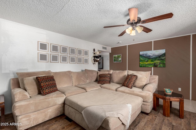 living room with ceiling fan, wood-type flooring, and a textured ceiling