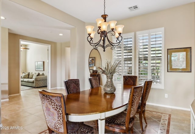 tiled dining area featuring an inviting chandelier