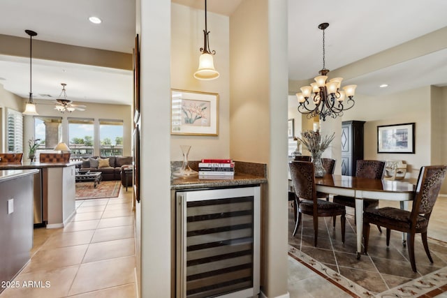 dining area featuring bar, light tile patterned floors, beverage cooler, and a chandelier