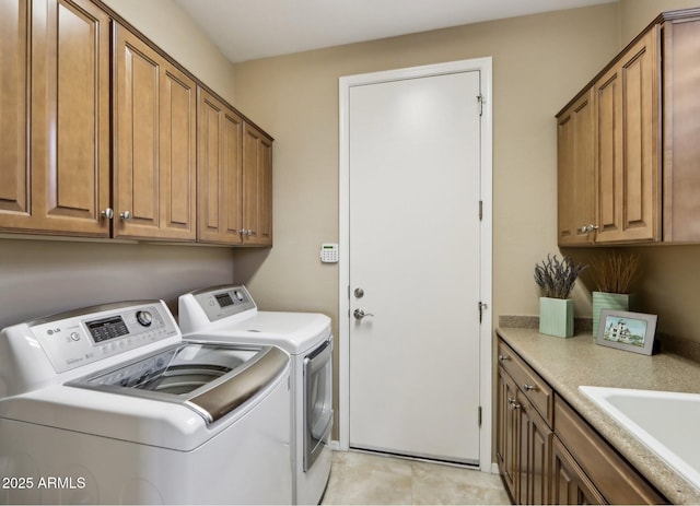 laundry area featuring separate washer and dryer, sink, and cabinets