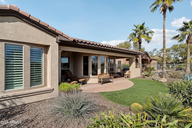 rear view of property featuring a yard and a patio area