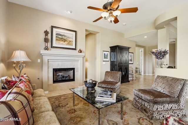 living room with a fireplace, ceiling fan, and light tile patterned flooring