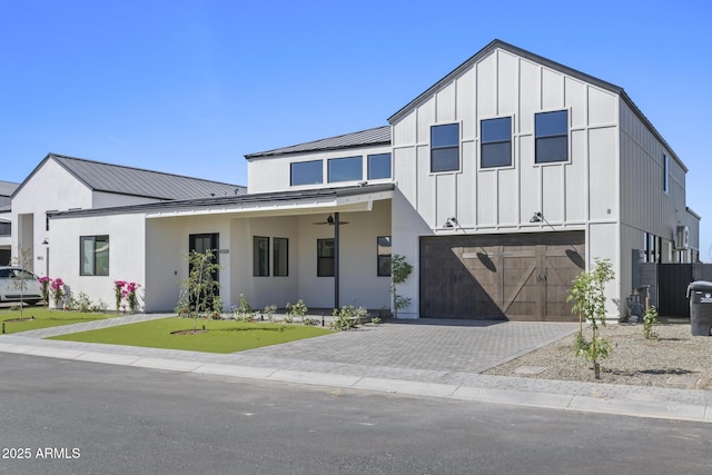 8503 S 9th Dr Unit 17, Phoenix, AZ 85041 - view of front of home with a garage, board and batten siding, decorative driveway, metal roof, and a standing seam roof