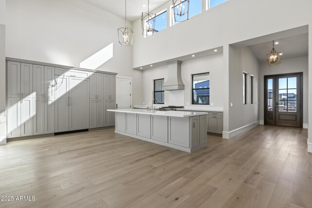 8503 S 9th Dr Unit 17, Phoenix, AZ 85041 - kitchen with a chandelier, custom exhaust hood, gray cabinetry, a towering ceiling, and light countertops