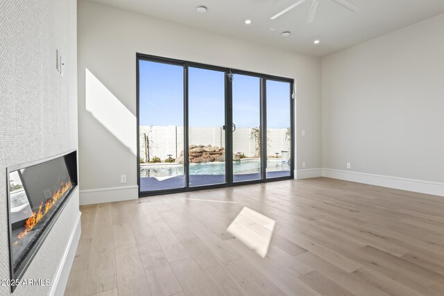 8503 S 9th Dr Unit 17, Phoenix, AZ 85041 - unfurnished living room with a glass covered fireplace, wood finished floors, ceiling fan, baseboards, and recessed lighting