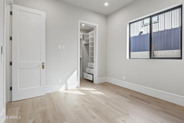 8503 S 9th Dr Unit 17, Phoenix, AZ 85041 - unfurnished bedroom with wood finished floors, baseboards, a spacious closet, a closet, and recessed lighting