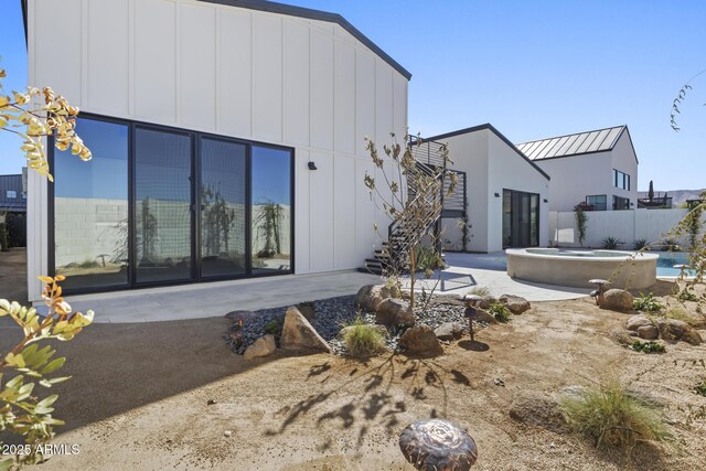 8503 S 9th Dr Unit 17, Phoenix, AZ 85041 - back of property with an in-ground hot tub, a patio area, fence, stairway, and board and batten siding