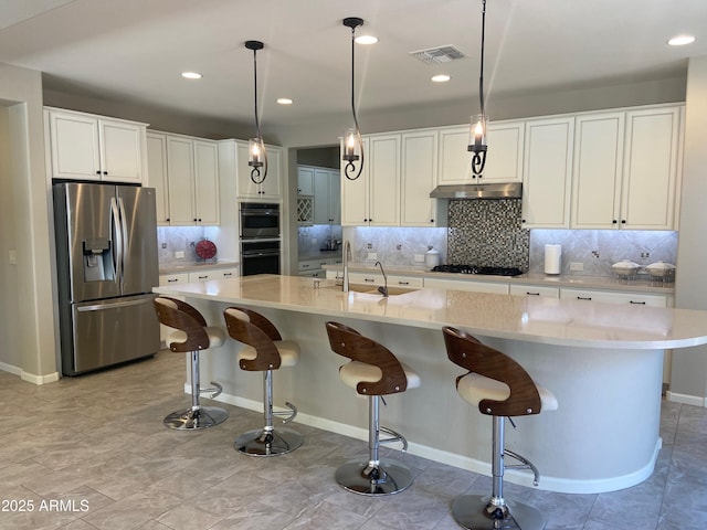 kitchen featuring visible vents, appliances with stainless steel finishes, white cabinets, a sink, and under cabinet range hood