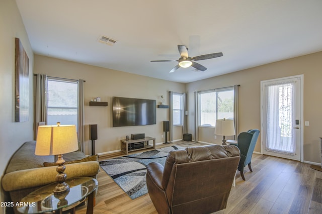 25659 W Forest Grove Ave, Buckeye, AZ 85326 - living room with baseboards, wood finished floors, and a ceiling fan