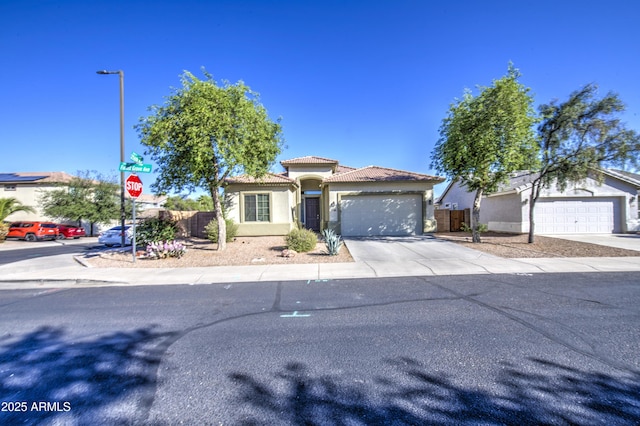 25659 W Forest Grove Ave, Buckeye, AZ 85326 - mediterranean / spanish-style home with driveway, stucco siding, a garage, and a tiled roof