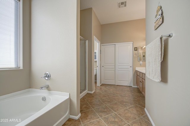 25659 W Forest Grove Ave, Buckeye, AZ 85326 - bathroom with baseboards, vanity, a bath, and a stall shower