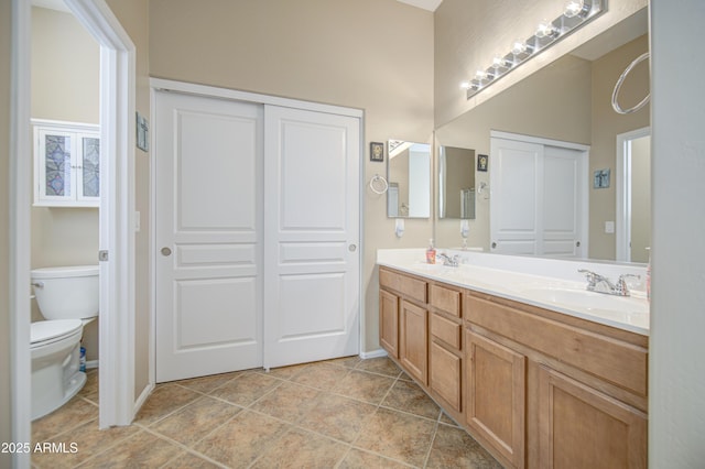 25659 W Forest Grove Ave, Buckeye, AZ 85326 - bathroom featuring double vanity, toilet, and baseboards
