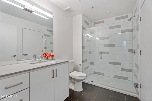 bathroom featuring tile patterned flooring, vanity, toilet, and an enclosed shower