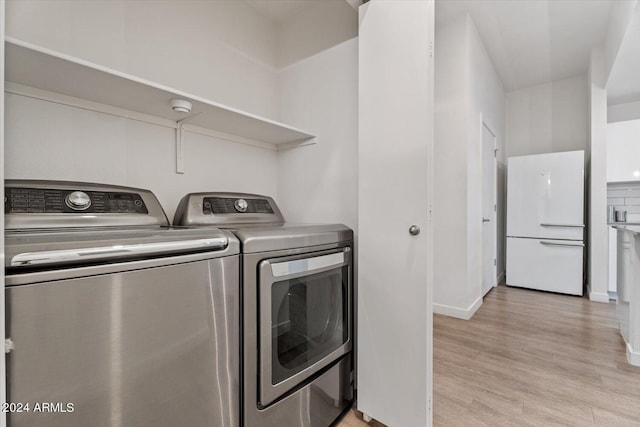 laundry area featuring washer and dryer and light hardwood / wood-style floors