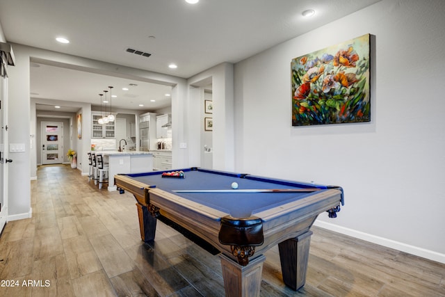 playroom with pool table, sink, and light hardwood / wood-style flooring