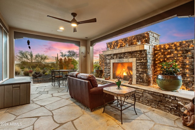 patio terrace at dusk featuring an outdoor stone fireplace