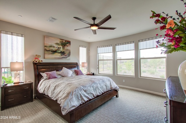 carpeted bedroom with multiple windows and ceiling fan