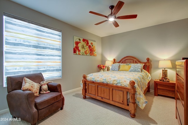 bedroom with ceiling fan, multiple windows, and light carpet