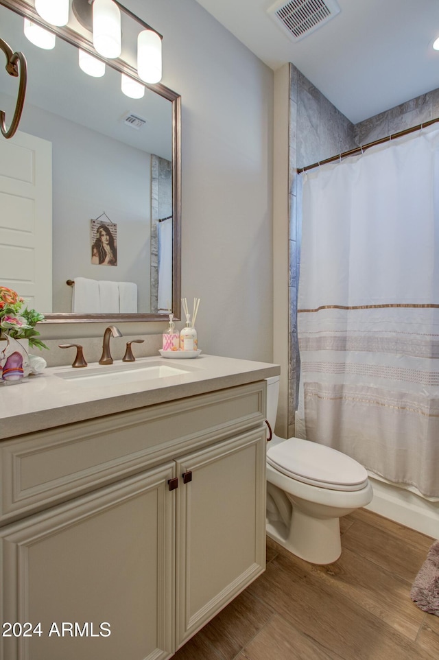 bathroom with hardwood / wood-style flooring, vanity, and toilet