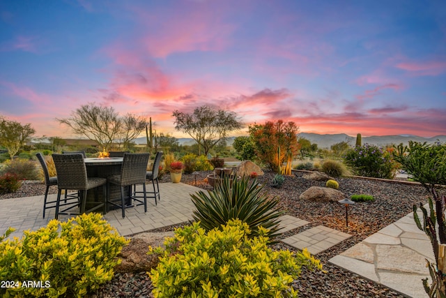 patio terrace at dusk featuring a mountain view