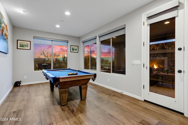 rec room featuring pool table, hardwood / wood-style floors, and a brick fireplace