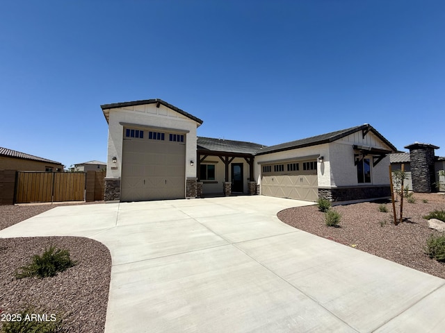 17324 W Royal Palm Rd, Waddell, AZ 85355 - view of front of house featuring stone siding, an attached garage, concrete driveway, a gate, and stucco siding