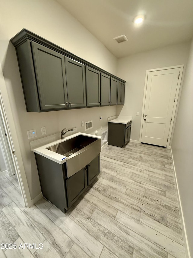 17324 W Royal Palm Rd, Waddell, AZ 85355 - washroom featuring cabinet space, washer hookup, light wood-style flooring, baseboards, and hookup for an electric dryer