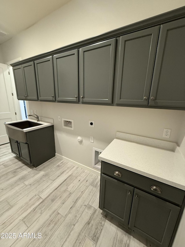 17324 W Royal Palm Rd, Waddell, AZ 85355 - laundry room with cabinet space, hookup for an electric dryer, hookup for a washing machine, light wood finished floors, and baseboards