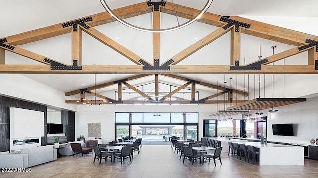 dining area with beam ceiling and high vaulted ceiling