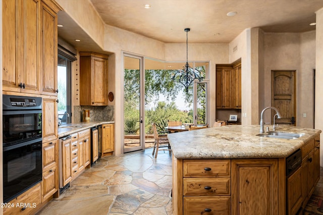 kitchen featuring hanging light fixtures, sink, beverage cooler, a center island with sink, and light stone countertops