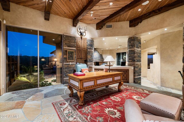 interior space featuring a high ceiling, beamed ceiling, wooden ceiling, and ornate columns